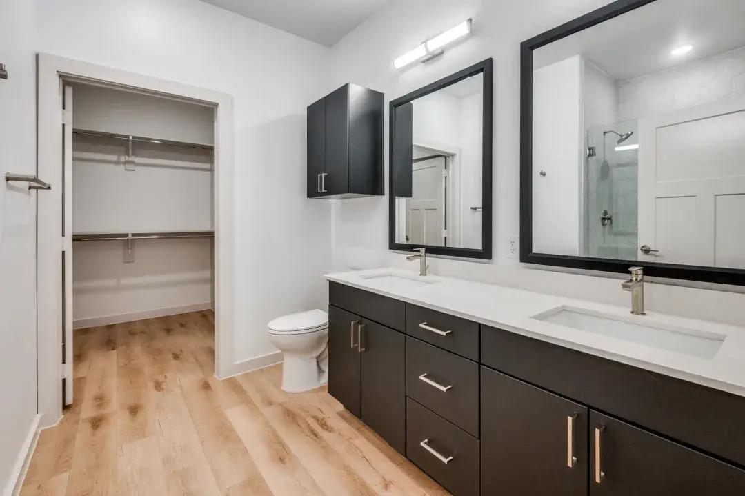 Bathroom with a double quartz vanity, matte black framed mirrors and a tiled walk-in shower