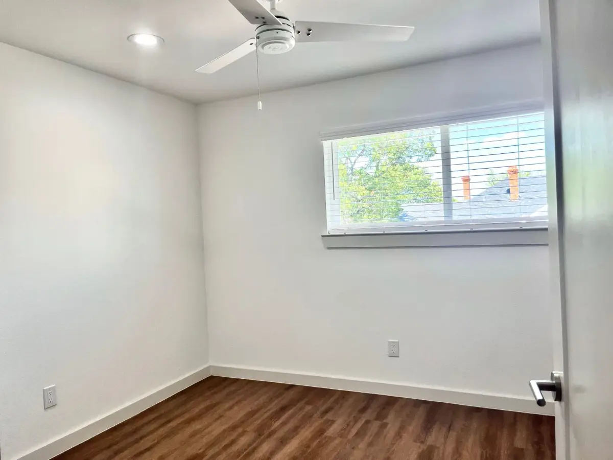 Bedroom with a ceiling fan, a blinded window, and hardwood-style flooring