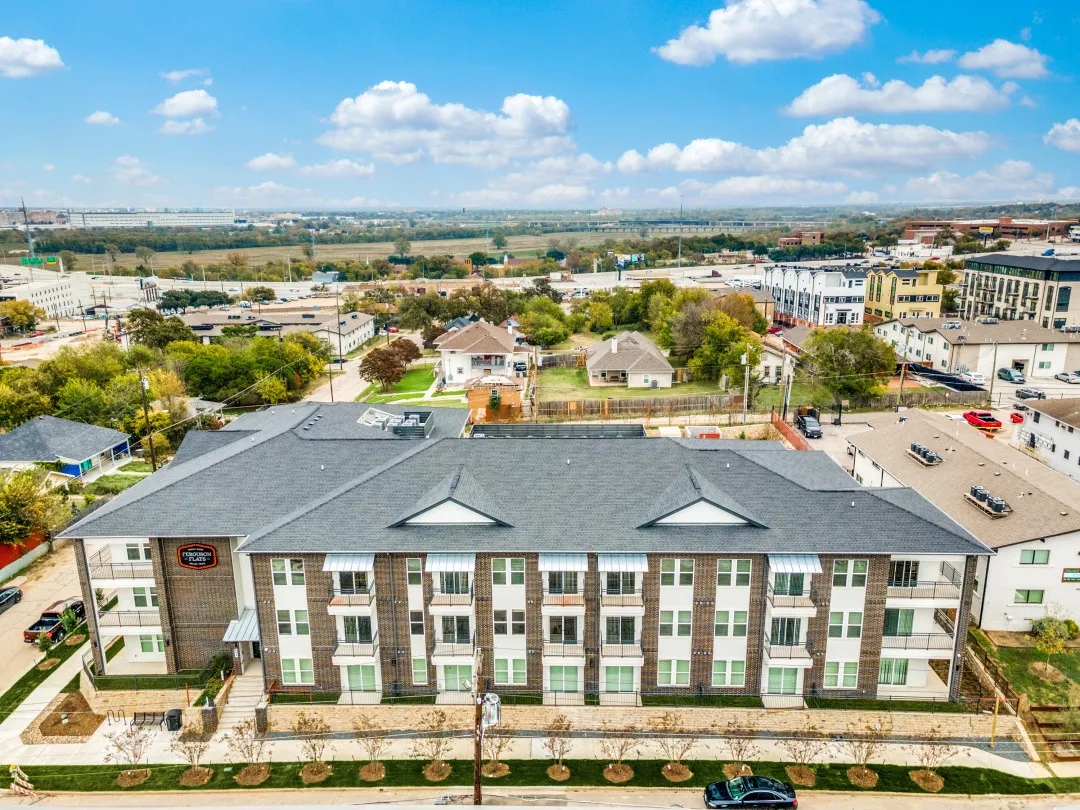 Aerial view of the three-story building's front elevation with new landscaping along the street