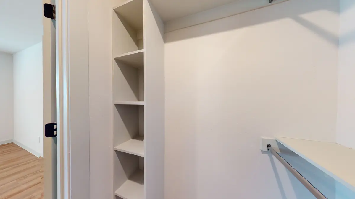 Walk-in closet with a built-in shelving tower and a hanging rod
