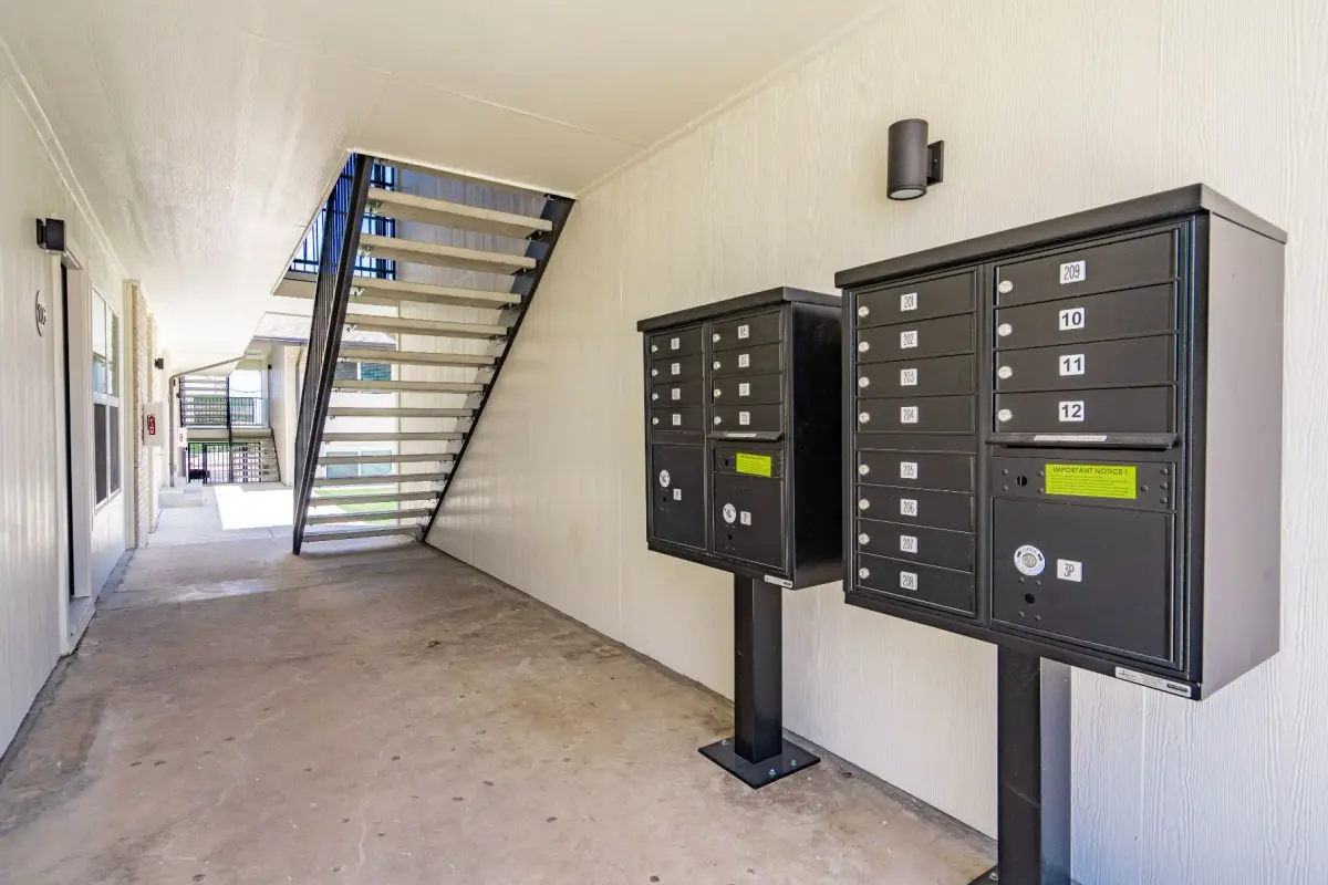 Covered breezeway with cluster mailboxes and an open-tread staircase