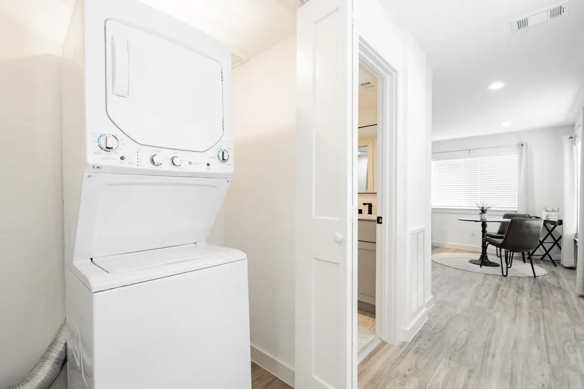 In-unit stacked washer and dryer in a closet beside a dining area