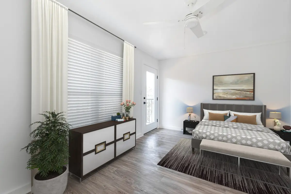Bedroom with a gray upholstered bed, nightstands, a dresser, and a glass door to a balcony