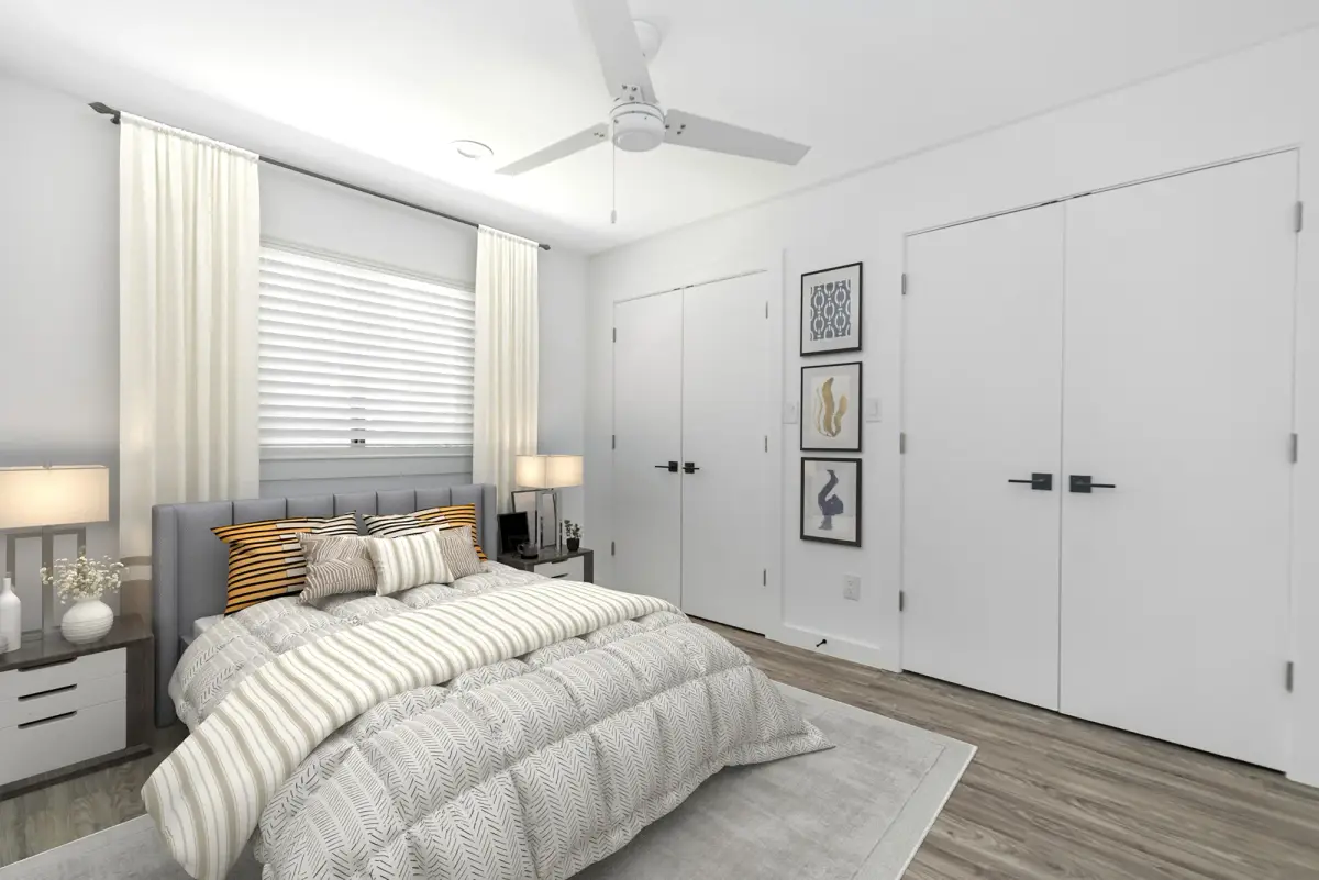 Bedroom with a gray upholstered bed, nightstands, framed gallery art, and two double closets