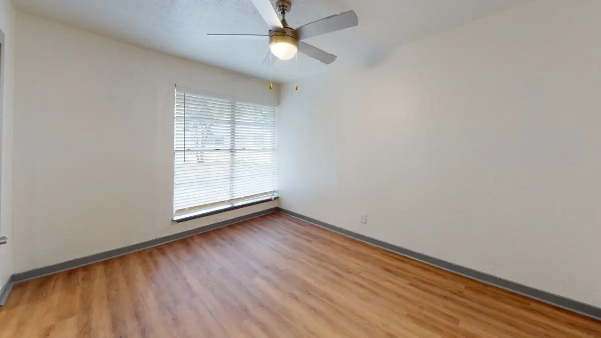 Bedroom with white walls, a ceiling fan, and a blinded window