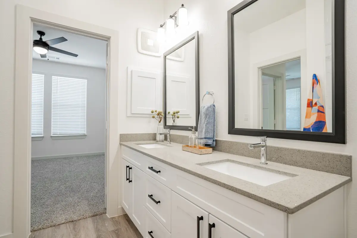 Bathroom with a quartz-topped vanity, framed mirror and matte black fixtures