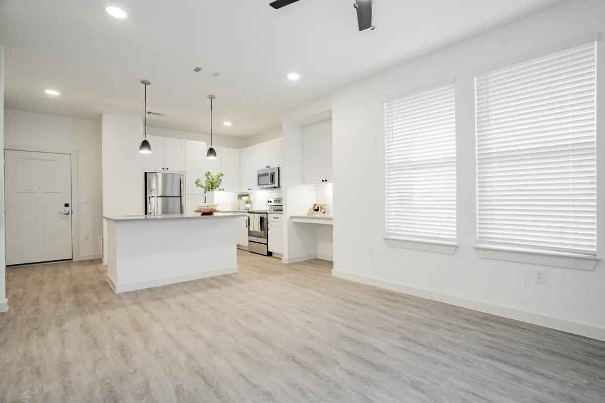 Open-concept living area off the kitchen with large windows and luxury vinyl plank flooring