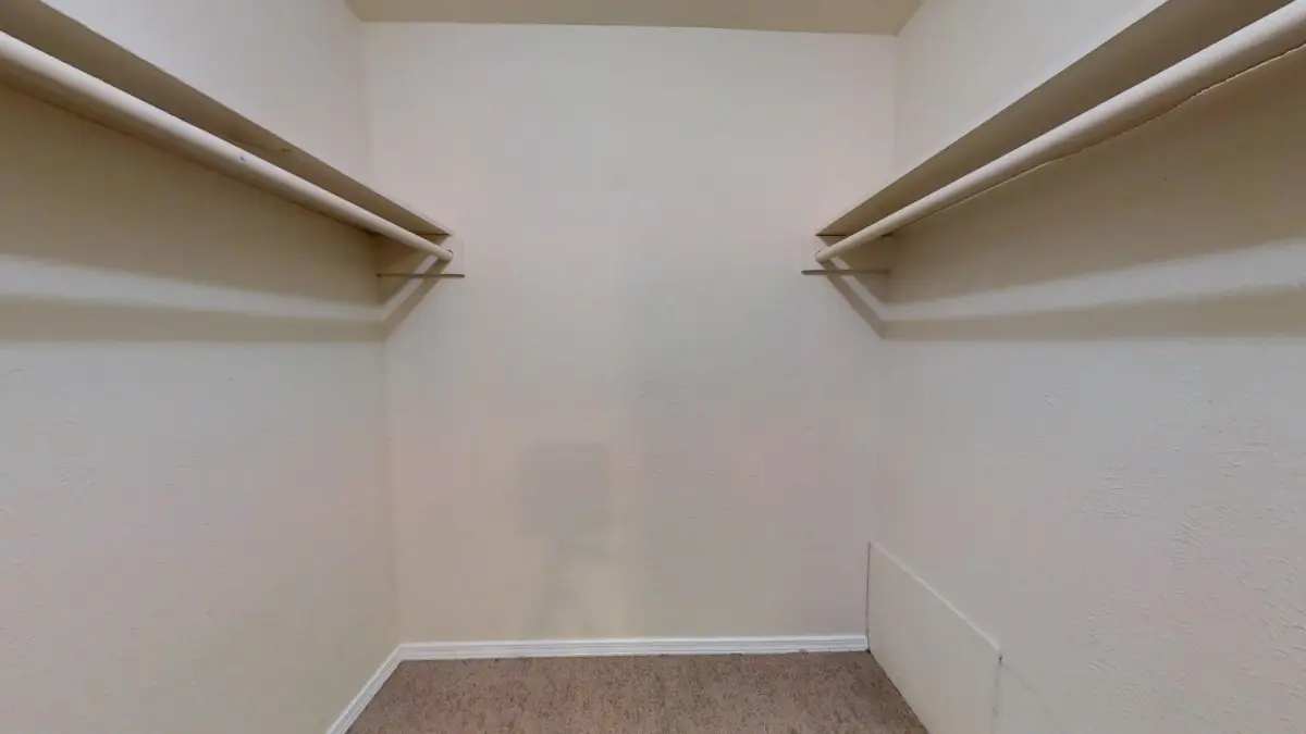 Walk-in closet with a shelf and hanging rods