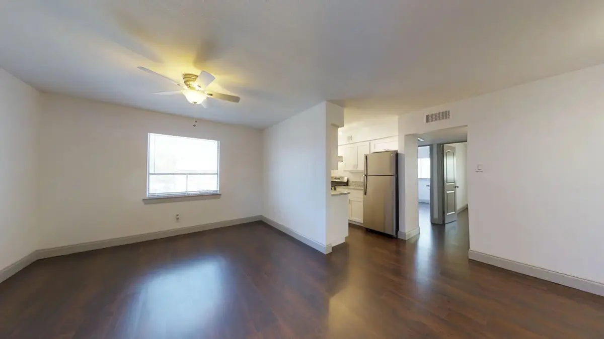 Open-concept living and dining space with wood-look flooring beside the kitchen