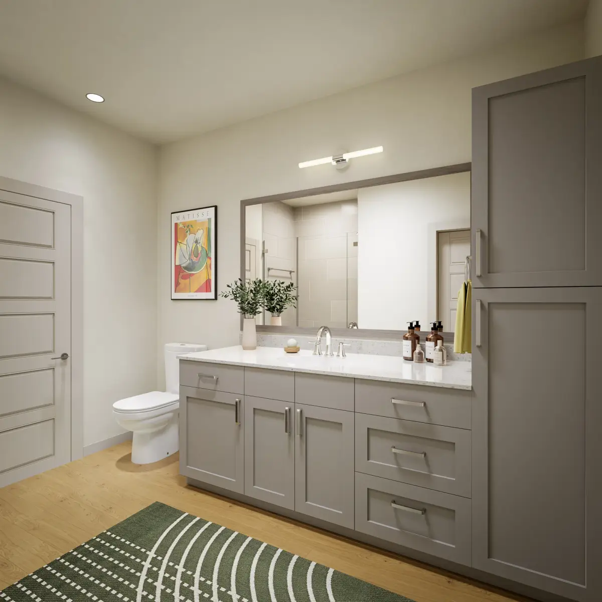 Bathroom with gray shaker vanity, quartz top, wide framed mirror, linen tower, and bar sconce lighting