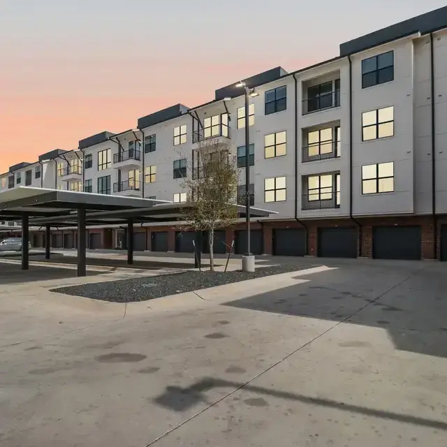 Exterior of The Bowie with covered parking and private garages at dusk