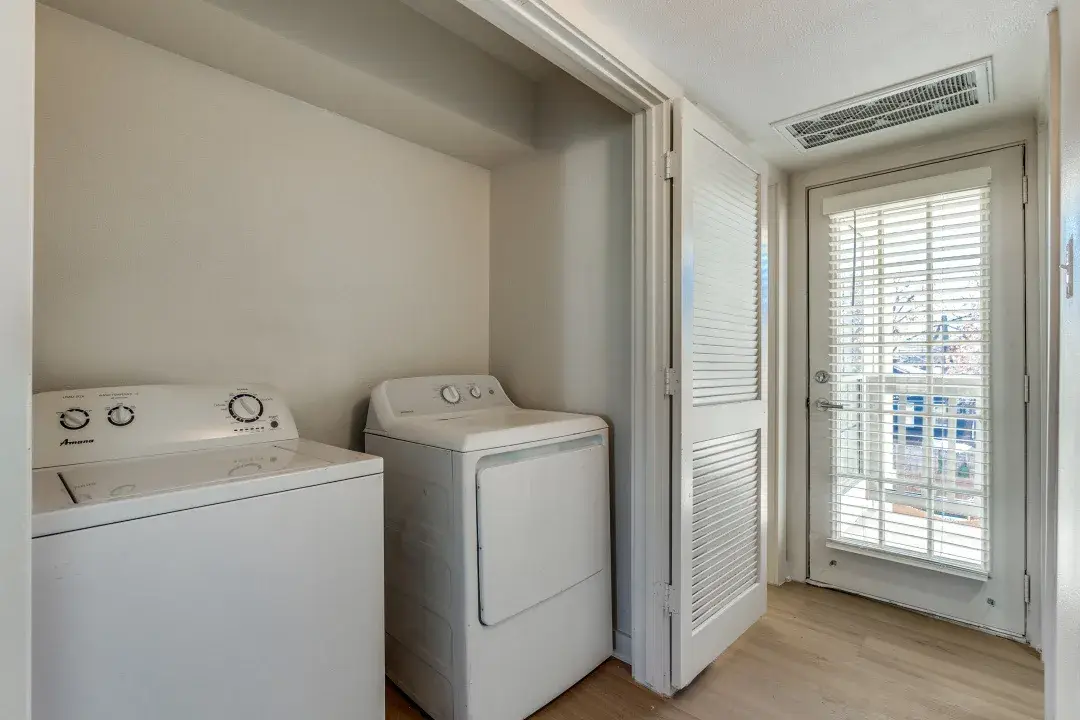In-home full-size washer and dryer in a closet beside a balcony door