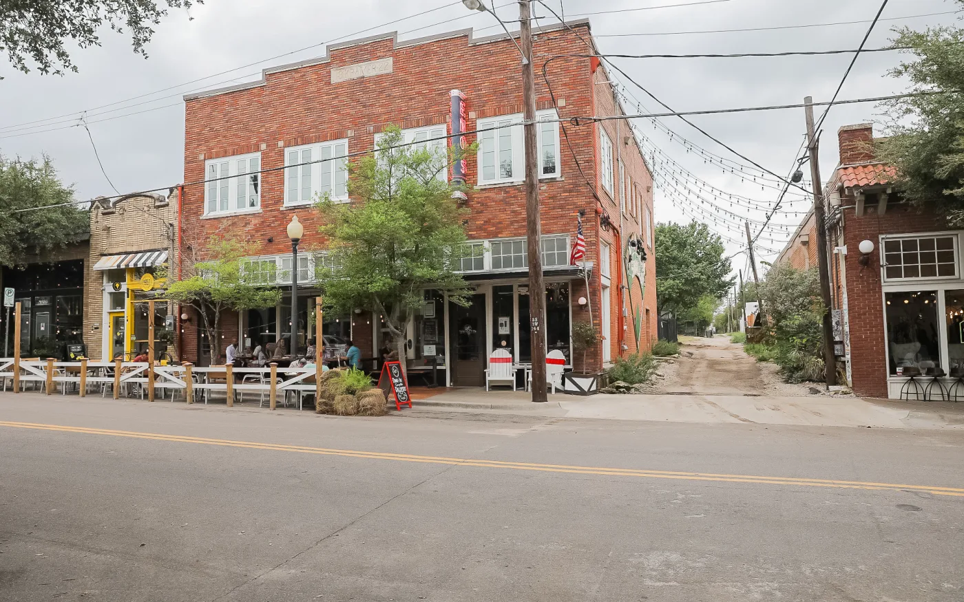 A century-old two-story brick corner with sidewalk dining in the Bishop Arts District